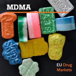 European drug markets report: MDMA. Photo of MDMA pills on black background