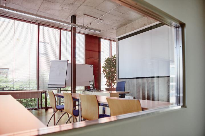 empty training room with chairs, tables, flipchart and white board